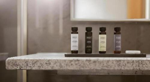 three bottles of essential oils sitting on a bathroom counter at Top Cloud Hotel Iksan in Iksan