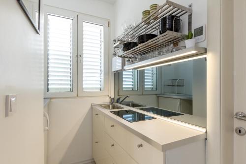 una cucina con armadi bianchi e lavandino di Studio apartment Petra a Spalato (Split)