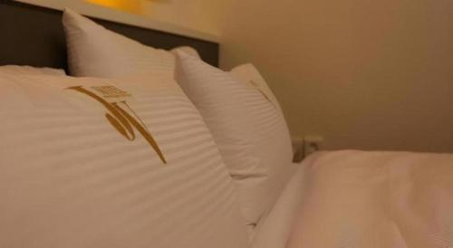 a white bed with white pillows on top of it at Java Hotel in Daejeon