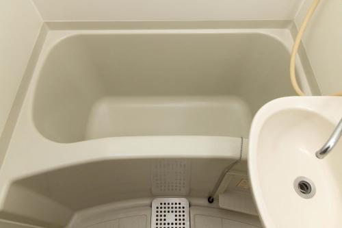 a bath tub with a sink in a bathroom at Befu Good Place House in Fukuoka