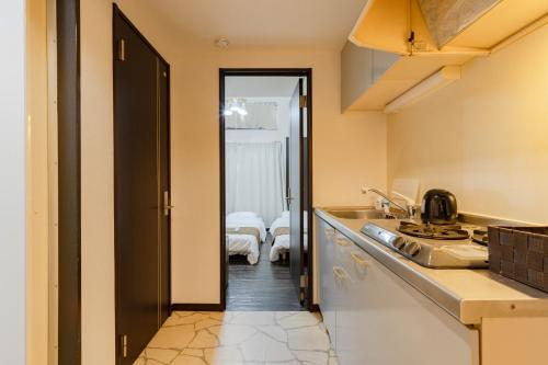 a kitchen with a hallway leading to a bedroom at Befu Good Place House in Fukuoka