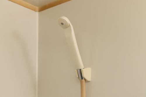 a shower head on the wall of a bathroom at Befu Good Place House in Fukuoka