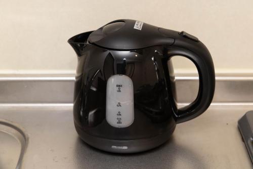 a black tea kettle with a remote control in it at Befu Good Place House in Fukuoka