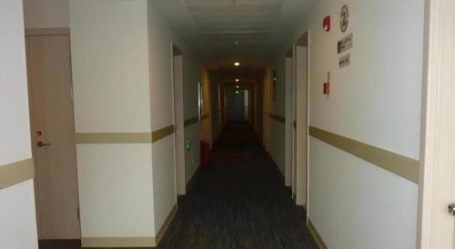 a hallway with a long hall with white walls at Jinjiang Inn Taizhou Huangyan Jiufeng Park in Daidong