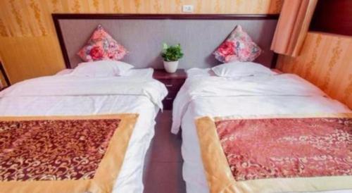 two beds sitting next to each other in a room at Pingyao Yufengheng Hotel in Pingyao