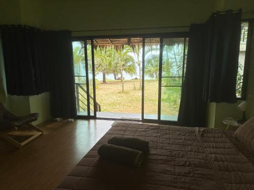 a bedroom with a large bed and a large window at KohMakHomeHug Resort in Ko Mak