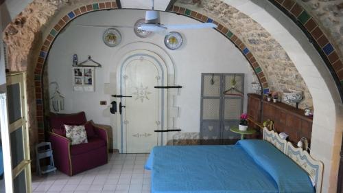 een slaapkamer met een blauw bed en een stoel bij Casa MaFaCò in Modica