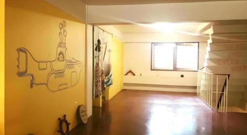 a living room with a drawing on the wall at Oldie and Sleepy Hostel in Udon Thani