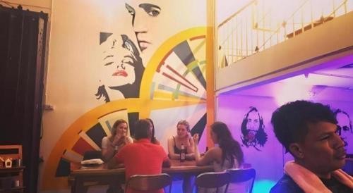 a group of people sitting at a table in a room at Oldie and Sleepy Hostel in Udon Thani