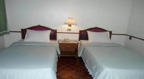 two beds sitting next to each other in a room at Ubon Hotel in Ubon Ratchathani