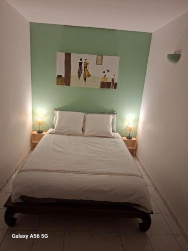 a bedroom with a bed with two lamps on two tables at Ti kaz Orion in Les Avirons