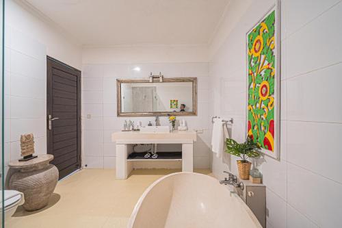 um banheiro branco com uma pia e um espelho em Sari Temuku Villa em Seminyak