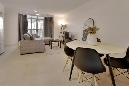 a living room with a table and chairs at Comfortable 1BR near UQ, River Walks & Pool in Brisbane