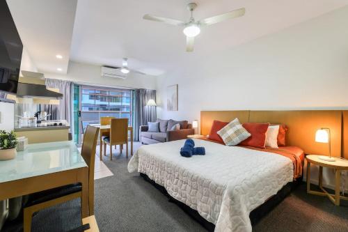 a bedroom with a bed and a living room at Darwin City Centre Studio Pool, Gym & Parking in Darwin