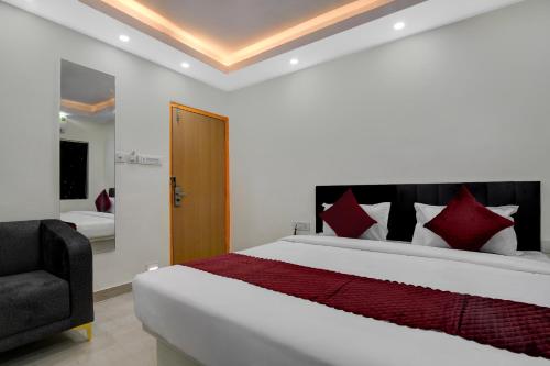 a bedroom with a large bed and a chair at Hotel Royal Place in Kolkata