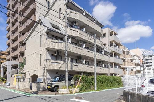 an apartment building with a van parked in front of it at Minami-Ohashi Good Place House in Fukuoka