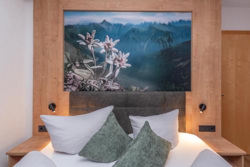 a painting is above a bed with pillows at Sonnwendhof in Ischgl