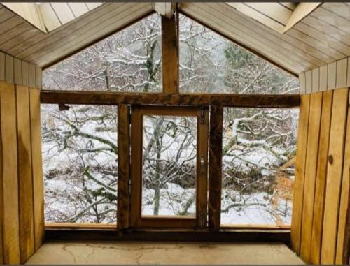 a window in a room with snow covered trees at Mirvana home stay in Kalgha