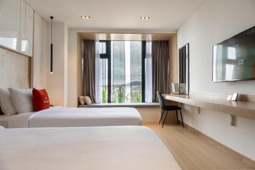 a hotel room with two beds and a desk at Colline Dalat in Da Lat