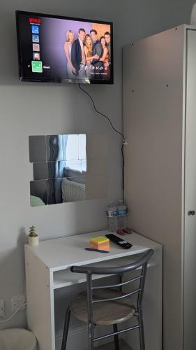 a desk with a chair and a tv on a wall at Room in Swanscombe, Kent in Swanscombe
