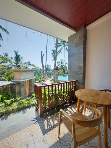 a patio with a table and chairs on a balcony at Puri Diamond Villas in Tampaksiring