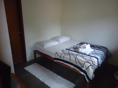 a small bedroom with a bed in a room at Pousada Aba da Serra in São Joaquim do Monte