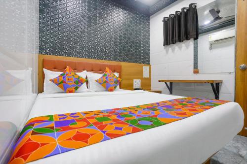 ムンバイにあるFabHotel Chembur Residencyのベッドルーム1室(大型ベッド1台、カラフルな掛け布団付)