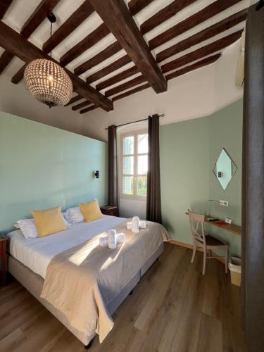 a bedroom with a large bed and a desk at La Solenzara hôtel - 3 Etoiles Supérieur - Appartement & SPA in Sari Solenzara