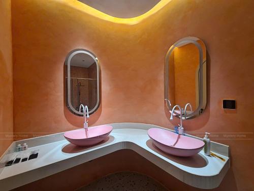 two sinks in a bathroom with two mirrors at MYSTERY HOME - NOVAWORLD PHAN THIET 3BR 120m2 in Bình Tú