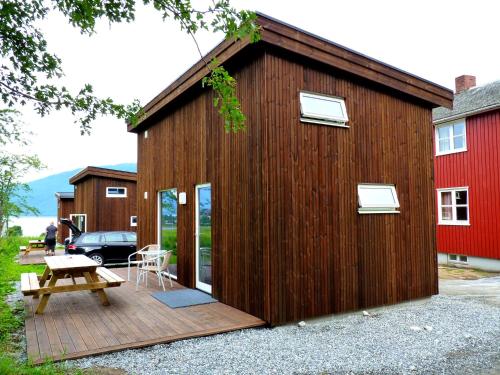 a wooden building with a deck and a picnic table at Setnes Feriesenter in Veblungsnes
