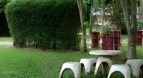 a picnic table and four benches in a park at Seaza Hotel in Chumphon