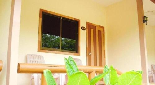 a room with a window and a table and chairs at Seaza Hotel in Chumphon