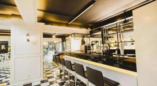 a restaurant with black chairs and a checkered floor at Grand Darmo Suite by AMITHYA in Surabaya