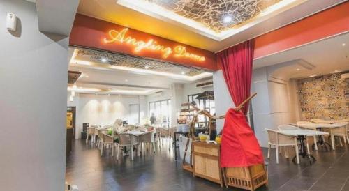 a restaurant with tables and chairs in a room at Grand Darmo Suite by AMITHYA in Surabaya