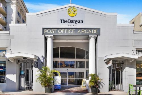 a post office arcade with palm trees in front of it at The Banyan Hotel Fort Myers, Tapestry Collection by Hilton in Fort Myers