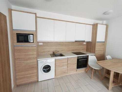 una cucina con lavatrice, asciugatrice e tavolo di Elizabeth 2 a Kecskemét