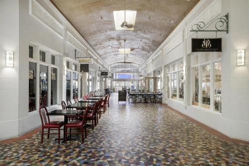 a hallway with tables and chairs in a restaurant at The Banyan Hotel Fort Myers, Tapestry Collection by Hilton in Fort Myers
