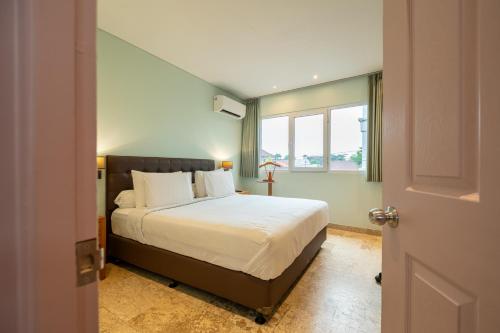 a bedroom with a bed and a window at Mirah Villas in Denpasar