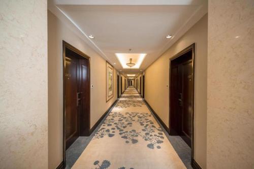 a hallway with a carpet with blue flowers on it at Jin Jiang Nanjing Hotel in Nanjing