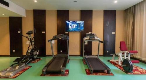 a gym with several exercise bikes and a television at Jin Jiang Nanjing Hotel in Nanjing