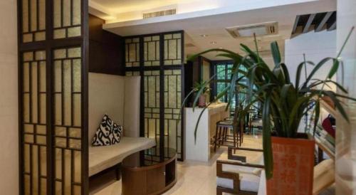 a living room with a couch and some plants at Jin Jiang Nanjing Hotel in Nanjing
