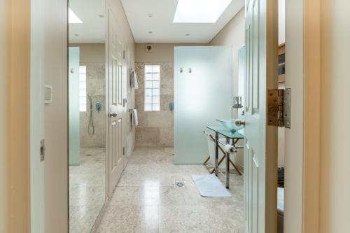 a bathroom with a walk in shower and a sink at Mirah Villas in Denpasar