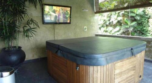 a room with a bath tub with a tv on the wall at D Villas in Colombo
