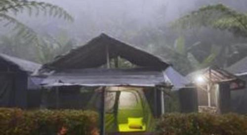a green truck with a roof in the rain at Herman Lantang Camp in Bogor