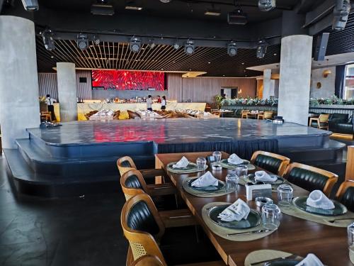 a restaurant with wooden tables and chairs and a large stage at Luxurious Apartments at Grand Sapphire Resort & Casino in Bahçeler
