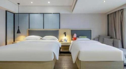 Ein Bett oder Betten in einem Zimmer der Unterkunft Echarm Hotel Beihai Railway Station