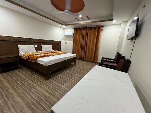 una habitación de hotel con una cama y un televisor en Regent palaza, en Dargai