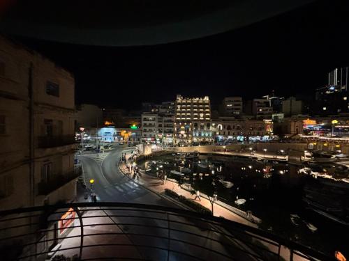 a view of a city at night with at Bay View Apartments in St Julian's