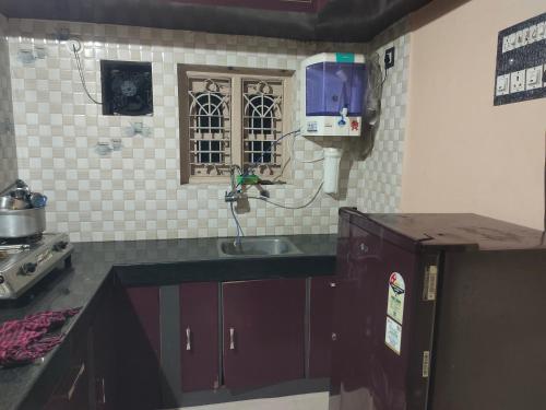 Una pequeña cocina con fregadero y ventana. en Tanvi Guest House Hampi, en Hampi