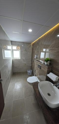 a bathroom with a sink and a toilet at Broadway Inn in Mysore